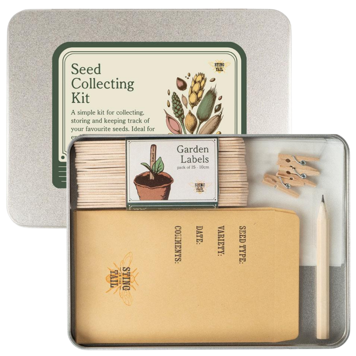 Seed Collecting Kit by Sting in the Tail in a square metal tin, shown open with kraft paper seed envelopes, wooden garden labels, small wooden clothespins, glassine envelopes and a pencil.